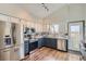 Eat-in kitchen with stainless steel appliances, and white and navy blue cabinets at 4783 S Taft St, Morrison, CO 80465