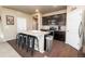 Modern kitchen featuring dark cabinets, a spacious island with seating, and stainless steel appliances at 19468 E 65Th Pl, Aurora, CO 80019