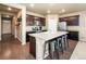 Beautiful kitchen featuring dark cabinets, a large island with seating, and stainless steel appliances at 19468 E 65Th Pl, Aurora, CO 80019