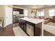 Bright, open kitchen with a large island, stainless steel appliances, and adjacent dining area at 19468 E 65Th Pl, Aurora, CO 80019