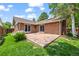 Home's backyard featuring a red brick exterior, concrete patio, and lush greenery at 37 E 14Th Pl, Broomfield, CO 80020