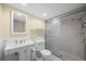 Bathroom featuring a glass shower stall, white sink and toilet, paneled walls, and recessed lights at 37 E 14Th Pl, Broomfield, CO 80020