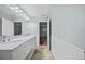 Bright bathroom featuring double vanity, mirrors, and paneled walls at 37 E 14Th Pl, Broomfield, CO 80020