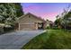 Charming exterior of a home with a lush green lawn and a driveway leading to an attached garage at sunset at 37 E 14Th Pl, Broomfield, CO 80020