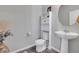 Small bathroom with pedestal sink, toilet, and storage cabinet at 533 Pioneer Ct, Fort Lupton, CO 80621