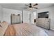 Main bedroom with king bed, ceiling fan, dresser and view into bathroom at 533 Pioneer Ct, Fort Lupton, CO 80621