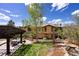 Beautiful backyard with patio, pergola, lush lawn, mature trees, and elegant architectural home at 722 Evening Star Dr, Castle Rock, CO 80108