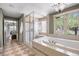 Bright bathroom featuring a soaking tub, glass shower, and tiled floor at 722 Evening Star Dr, Castle Rock, CO 80108