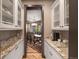 Butler's pantry with granite countertops, custom cabinets, and a serving area to the dining room at 722 Evening Star Dr, Castle Rock, CO 80108