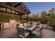 An inviting outdoor kitchen and dining area featuring a built-in grill, pergola, and comfortable seating at 722 Evening Star Dr, Castle Rock, CO 80108