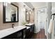 Bathroom boasts double vanity with black cabinets, mirrors, and stylish wood-look flooring at 6341 E Floyd Dr, Denver, CO 80222