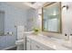 Charming bathroom with patterned wallpaper, single vanity and gold framed mirror at 6341 E Floyd Dr, Denver, CO 80222