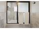 Tiled shower/tub with sliding glass door, and built-in shelving creates spa-like retreat at 6341 E Floyd Dr, Denver, CO 80222