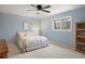 Light blue bedroom features a ceiling fan, window, and built in bookshelf at 6341 E Floyd Dr, Denver, CO 80222