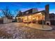 Rear view of a home featuring a brick facade and a covered patio with outdoor seating at 6341 E Floyd Dr, Denver, CO 80222