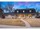 Charming two-story brick home featuring a covered front porch and well-maintained lawn at 6341 E Floyd Dr, Denver, CO 80222