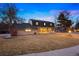 Classic two-story home with a welcoming front porch, expansive lawn, and mature trees at 6341 E Floyd Dr, Denver, CO 80222