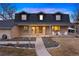 Charming two-story home with a brick facade, covered porch, and inviting curb appeal at dusk at 6341 E Floyd Dr, Denver, CO 80222