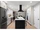 Modern kitchen featuring white cabinets, a black island, stainless steel appliances, and wood floors at 6341 E Floyd Dr, Denver, CO 80222