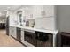 Stylish kitchen featuring white cabinets, a stainless steel dishwasher, a wine cooler, and a microwave at 6341 E Floyd Dr, Denver, CO 80222