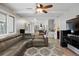 Cozy living room with a gray sectional sofa, ceiling fan, and open layout to the kitchen at 6341 E Floyd Dr, Denver, CO 80222