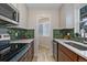 Modern kitchen with stainless appliances, quartz countertops, and green tiled backsplash at 2253 Kipling St, Lakewood, CO 80215