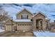 Charming two-story home showcasing a 3-car garage, stone accents, and a welcoming covered entryway at 14096 Roaring Fork Cir, Broomfield, CO 80023