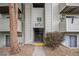 Exterior view of the building entrance with unit number signage, shrubbery, and concrete walkway at 10150 E Virginia Ave # 7-304, Denver, CO 80247