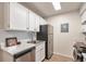 Galley-style kitchen with stainless steel appliances, and white cabinets at 10150 E Virginia Ave # 7-304, Denver, CO 80247