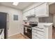 Galley-style kitchen with stainless steel appliances, white cabinets, and tile backsplash at 10150 E Virginia Ave # 7-304, Denver, CO 80247