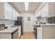 Galley-style kitchen with white cabinets, stainless steel appliances, and tile backsplash at 10150 E Virginia Ave # 7-304, Denver, CO 80247