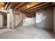 Unfinished basement with open ceiling, cement walls, and framed stairs at 11519 Wray Ct, Parker, CO 80134