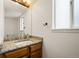 Bathroom featuring granite countertop, wood cabinets, and natural light at 11519 Wray Ct, Parker, CO 80134
