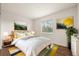 Bright bedroom featuring a large window, wood floors, and colorful art on the walls at 11519 Wray Ct, Parker, CO 80134