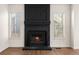 Fireplace with a black brick surround and hearth, flanked by bright windows, set on hardwood floors at 11519 Wray Ct, Parker, CO 80134