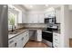 Updated kitchen featuring stainless steel appliances, granite countertops, and white cabinetry at 11519 Wray Ct, Parker, CO 80134
