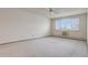 Well-lit bedroom featuring neutral carpeting, a ceiling fan, and a window with blinds at 9625 E Center Ave # 5C, Denver, CO 80247