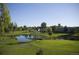 Scenic view of lush green golf course with pond, trees, and residential buildings in the background at 9625 E Center Ave # 5C, Denver, CO 80247