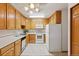 Traditional kitchen design with oak cabinetry, white appliances, and tile flooring at 9625 E Center Ave # 5C, Denver, CO 80247
