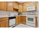 Kitchen with white countertops and appliances complemented by warm wooden cabinets at 9625 E Center Ave # 5C, Denver, CO 80247