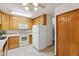 Well-lit kitchen featuring wooden cabinets, white appliances, and linoleum flooring at 9625 E Center Ave # 5C, Denver, CO 80247