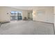 Spacious living room featuring neutral carpeting and a sliding glass door to the balcony at 9625 E Center Ave # 5C, Denver, CO 80247
