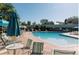 Outdoor pool with blue lounge chairs and umbrella covered tables at 9625 E Center Ave # 5C, Denver, CO 80247