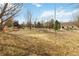 Large backyard featuring trees, a deck, and a swing set, offering plenty of space for recreation and relaxation at 1133 Northridge Dr, Erie, CO 80516