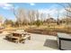 Expansive backyard with a deck, retaining walls, picnic table, and mature trees, perfect for outdoor activities at 1133 Northridge Dr, Erie, CO 80516