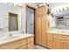 Bathroom with a double sink vanity, wooden cabinets, and a large mirror at 1133 Northridge Dr, Erie, CO 80516