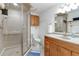 Modern bathroom boasts a stand-up shower with a glass door, a vanity, and a matching mirror and lighting at 1133 Northridge Dr, Erie, CO 80516
