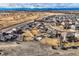 Aerial view of homes with large fenced yards in a neighborhood near open land and mountain views at 8768 Foxfire St, Firestone, CO 80504