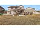 Exterior of home with back deck, grassy yard, and privacy fence on a sunny day at 8768 Foxfire St, Firestone, CO 80504