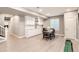 Basement wet bar features white cabinets, light wood floors, and dining area with seating for four at 8768 Foxfire St, Firestone, CO 80504